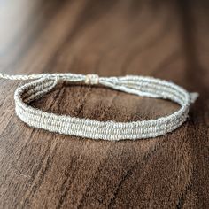 a white string bracelet sitting on top of a wooden table