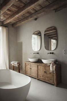 a bathroom with two sinks, mirrors and a bathtub in the middle of it