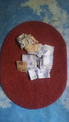 a pile of money sitting on top of a red rug