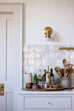 a kitchen counter with utensils and bottles on it