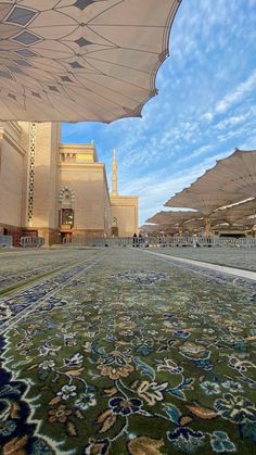 an outdoor area with many umbrellas and rugs