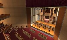 an empty auditorium with rows of chairs and tables in the center, looking down at the stage