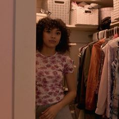 a woman standing in front of a closet full of clothes