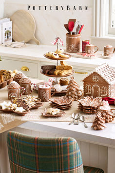 a table topped with lots of different types of cookies and pastries next to a window