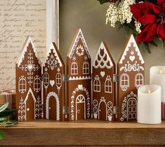 a group of gingerbread houses sitting on top of a table next to a candle