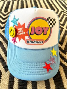 a blue and white hat that says joy on the front, with stars around it