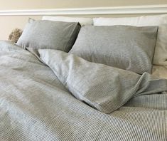 an unmade bed with two pillows on it