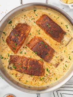 fish fillets are cooked in a skillet on the stove with lemons and parsley