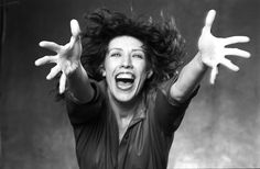 a black and white photo of a woman with her hands in the air