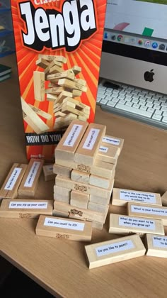 a pile of wooden blocks sitting on top of a desk next to a box of candy