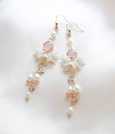 Be the belle of the ball with our SARINA earrings. Handcrafted in a long, intricate floral design, bejeweled with luscious freshwater pearls and pink opal stones, these earrings will make you sparkle like no other. With a sophisticated and artful design, you'll be chic and elegant on your special day. - Handcrafted in my studio in PA- Freshwater pearls- Polymer clay flowers- Yellow gold finish is pictured. Available in yellow gold or rhodium (silver)- Earrings measure 3.25 inches- Handcrafted in