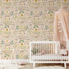 a baby's room with a crib and wallpaper