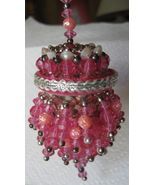 a pink beaded candle holder on a white table