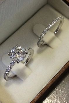 two engagement rings sitting in a box