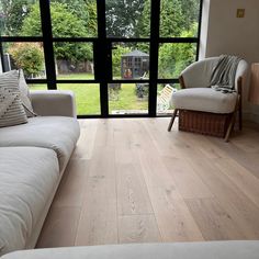 a living room filled with furniture and large windows