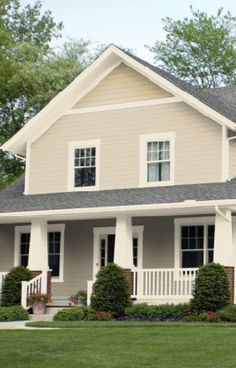 a large gray house with white trim and windows