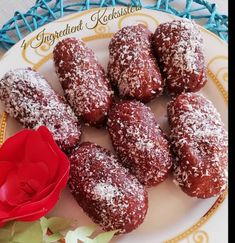 a white plate topped with pastries next to a red rose