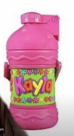 a pink plastic bottle with the word kyp on it's side and a woman's face behind it