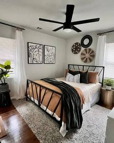 a bed room with a neatly made bed and a ceiling fan