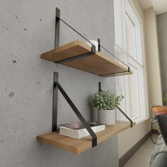 two wooden shelves with metal brackets are on the wall next to a potted plant