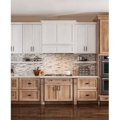 a kitchen with white cabinets and wood floors