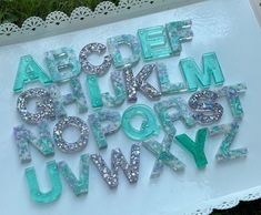 the letters are made out of plastic and have glitters on them, as well as lace