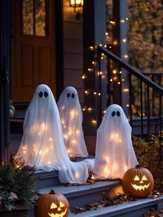 halloween decorations with ghost faces and lights on the steps