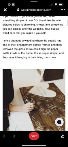 a person writing on a piece of paper next to a wooden sign with the word love written