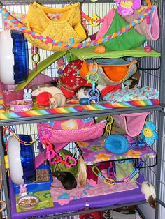 a cage filled with lots of toys and stuffed animals on top of each other's shelves