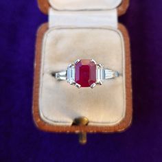 Ruby Diamond 18ct Gold Ring Striking elegant Art Deco style contemporary ring, featuring a natural emerald cut ruby nestled between a matching pair of baguette diamonds. The shoulders are embellished with a pair of tapered baguette cut diamonds.  This stunning vivid ruby is a beautiful shade of berry red with flashes of deep pink, set in 18ct white gold. This ring would make an excellent choice as engagement ring.  * Valuation certificate supplied, new replacement value £5,795.00 Ruby: 1.8ct, 7. Gia Certified Baguette Cut Ruby Ring, Gia Certified Ruby Jewelry With Baguette Cut, Gia Certified Baguette Cut Ruby Jewelry, Gia Certified Emerald Cut Ruby Ring, Baguette Cut Ruby Ring For Anniversary, Emerald Cut Hallmarked Ruby Ring For Gift, Luxury White Gold Emerald Cut Ruby Ring, Gia Certified Emerald Cut Ruby Ring In White Gold, Wedding Ruby Ring, Gia Certified, Emerald Cut