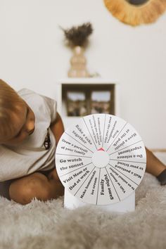 a baby sitting on the floor next to a spinning wheel