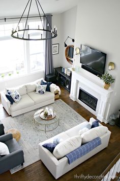 a living room filled with furniture and a flat screen tv mounted on the wall above a fireplace