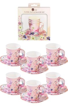 six pink coffee cups and saucers with floral designs on the rim, in front of a