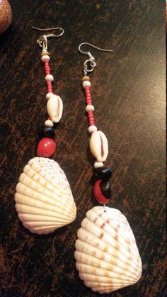 Lovely and delicate shells earrings. Made of cowrie and other shell with added white wooden beads, red beads and black and red seeds. Looking adorable while wearing. Length : 4.7 inch. Red Large Beads Jewelry For Beach, Red Large Beaded Jewelry For Beach, White Cowrie Shell Earrings For The Beach, Beach Wooden Bead Earrings, Red Beaded Earrings For Beach, Red Beaded Earrings With Dangling Beads For Beach, Beach Dangle Jewelry With Large Beads, Bohemian White Dangle Shell, White Round Bead Earrings For Beach