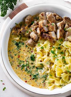 a white bowl filled with pasta and meat