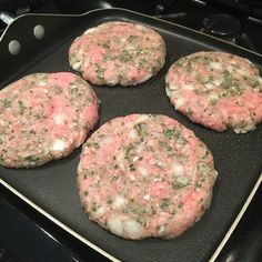 four hamburger patties cooking in a pan on top of an electric stovetop oven