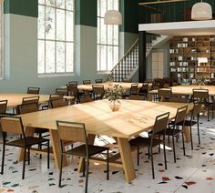 a dining room with tables and chairs in front of a book shelf filled with books