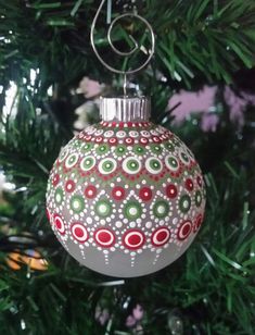 an ornament hanging from a christmas tree decorated with red, green and white ornaments