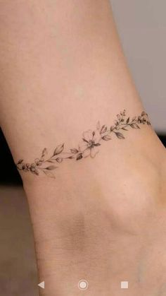 a woman's foot with a small flower tattoo on the left side of her ankle