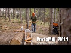 a man standing in the woods next to a log with a chainsaw on it