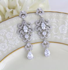 Rose gold cubic zirconia Bridal earrings in a modern vintage style chandelier style. Choose crystal drop or pearl drop from the drop down menu. Earrings are a perfect statement piece for any bride or other special occasion. Earrings measure 3 inches long and are 1 inch at their widest. Available in rose gold or rhodium finish. Back to my shop: https://www.etsy.com/shop/TheExquisiteBride?ref=condensed_trust_header_title_items Glamorous Crystal Chandelier Earrings With Elegant Design, Ornate Wedding Diamond Drop Earrings, Elegant Chandelier Drop Earrings For Anniversary, Ornate Silver Chandelier Earrings For Wedding, Wedding Diamond Drop Earrings With Intricate Design, Intricate Design Diamond Drop Earrings For Wedding, Intricate Dangle Bridal Earrings With Cubic Zirconia, Intricate Design Diamond Dangle Earrings For Wedding, Intricate Cubic Zirconia Dangle Bridal Earrings