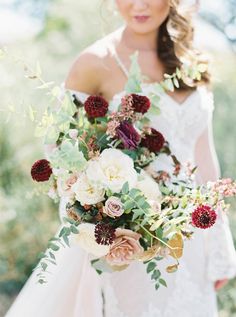 a woman holding a bouquet of flowers in her hands