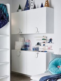 a bedroom with white cabinets and blue pillows