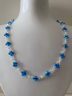 a necklace with blue glass beads on a mannequin