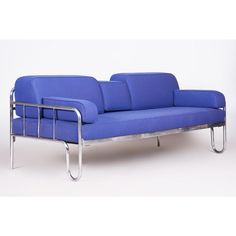 a blue couch sitting on top of a metal frame with arm rest and footrests