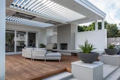 a white couch sitting on top of a hard wood floor next to a wooden deck