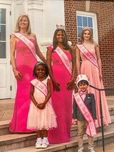 a group of women in pink dresses standing next to each other on steps with their children