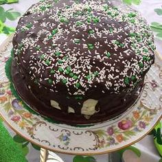 a chocolate cake with green sprinkles on a plate