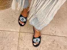 Step out in style with these stunning Greek leather evil eye sandals. Each pair is lovingly handmade by skilled artisans, ensuring that every detail is perfect. The evil eye design is a traditional Greek symbol believed to ward off negative energy, making these sandals not just stylish but also symbolic. Crafted from high-quality leather, these sandals are not only durable but also incredibly comfortable. The flat design is perfect for all-day wear, whether you're running errands or exploring a Beaded Eye, Black Evil Eye, Sandals Greek, Greek Symbol, Evil Eye Design, Slingbacks, Eye Design, Organza Gift Bags, Organza Bags