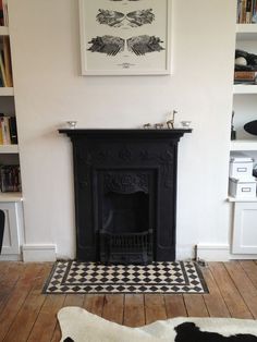 a dog laying on the floor in front of a fire place and bookshelves